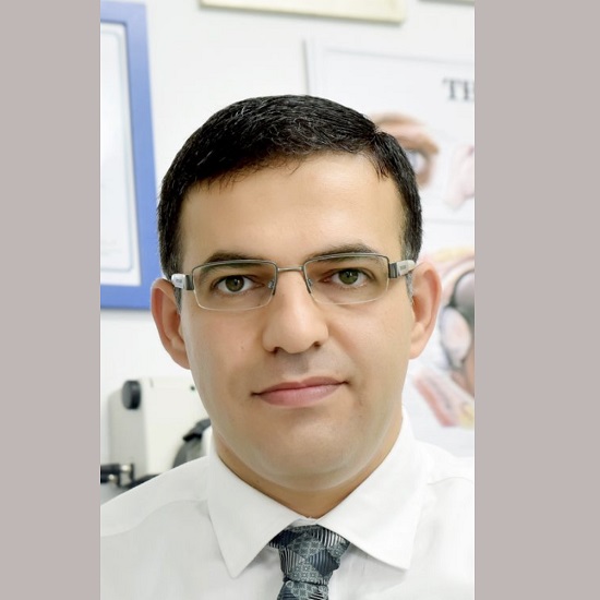 דיוקן מקצועי של ד"ר מוחמד גרה, רופא עיניים בכיר ומומחה למחלות וניתוחי רשתית וקטרקט מתקדמים, יושב בחדר בדיקות עיניים.